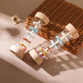 Montessori wooden rainmaker rattles with colorful beads on wicker basket