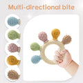 Montessori silicone teething ring with multi-directional textured attachments in baby's hand.