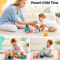 Mother and baby playing together with stacked Montessori squeaky building blocks on a living room rug.