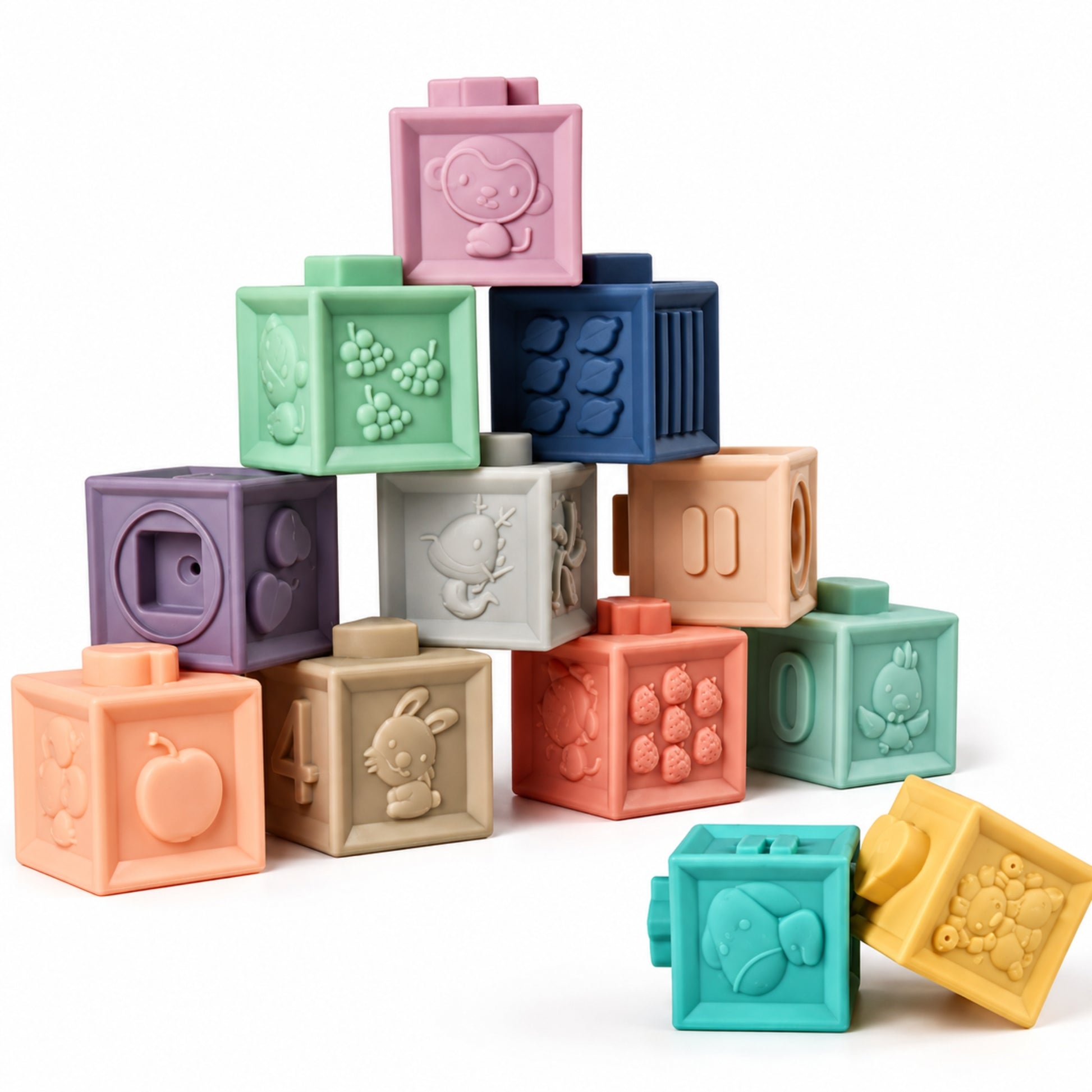 Montessori squeaky building blocks stacked in a pyramid, 12 pastel silicone cubes with embossed animals, fruit and numbers.